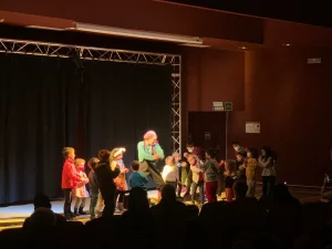 Photo of Sydney based actress Pamela Pilawa performing a family friendly theatre multilingual show surrounded by children